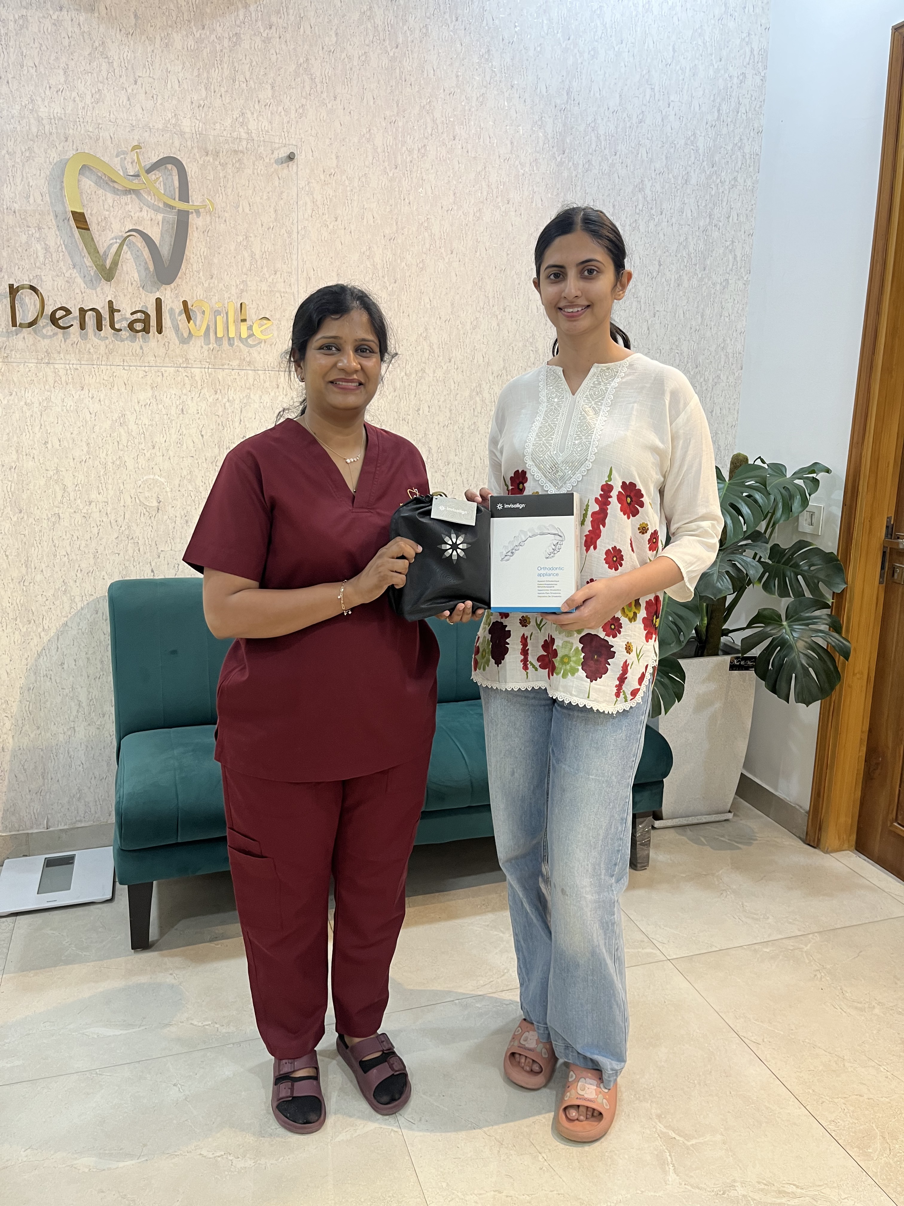 Happy dental client with Dental Ville team and aligner box